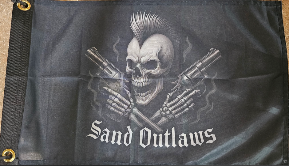 Flag with a skull holding guns and 'Sand Outlaws' text on a dark background