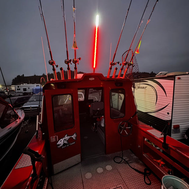 Red fishing boat interior with a lit red light against a dark sky.