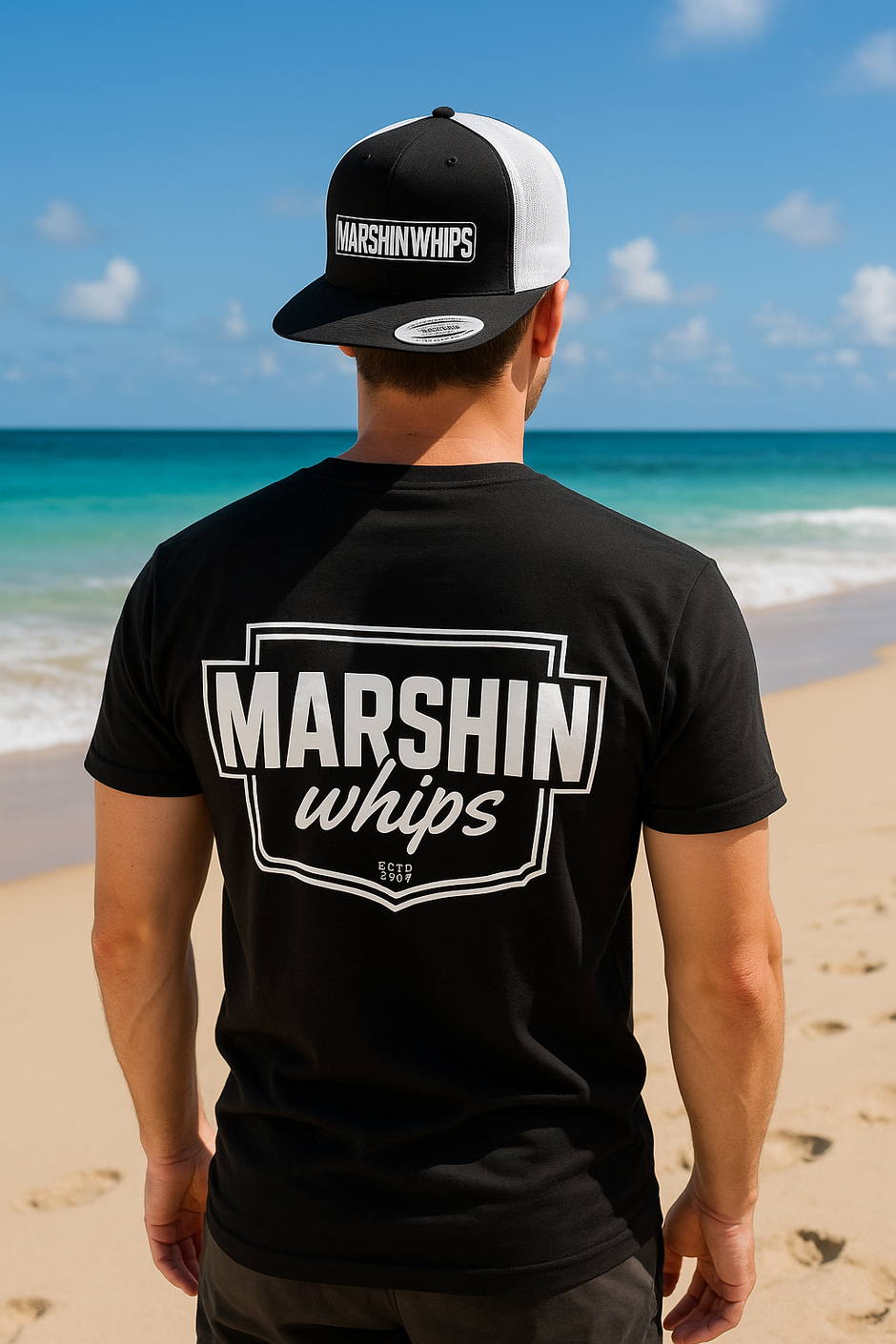 Person wearing a black t-shirt and cap with 'Marshin Whips' branding on a beach.