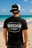 Person wearing a black t-shirt and cap with 'Marshin Whips' branding on a beach.